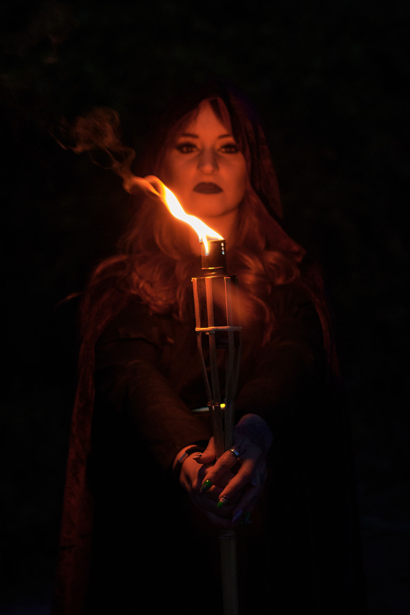 woman-disguised-as-a-witch-holding-a-flaming-torch-2022-03-30-00-02-21-utc.jpg